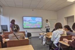 Zdjęcie przedstawia salę ćwiczeniową, grupę studentów i prowadzącą zajęcia